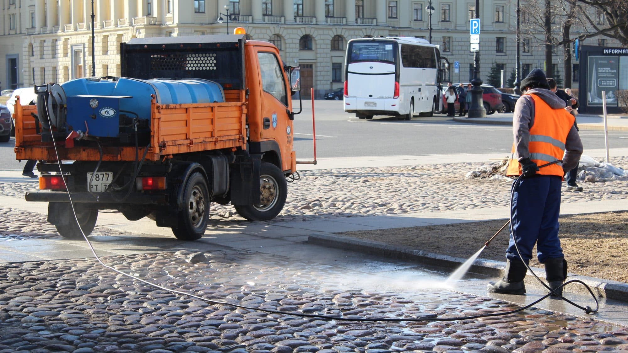 Operario limpiando el saneamiento de una calle con agua a alta presión