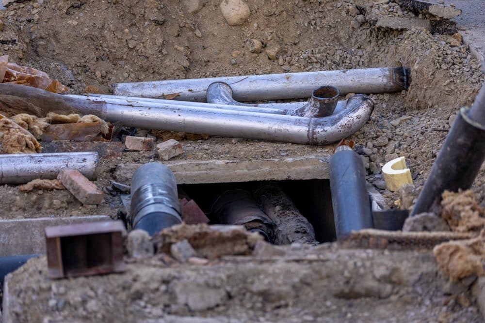 Tuberías de saneamiento al descubierto en una zanja durante una reparación